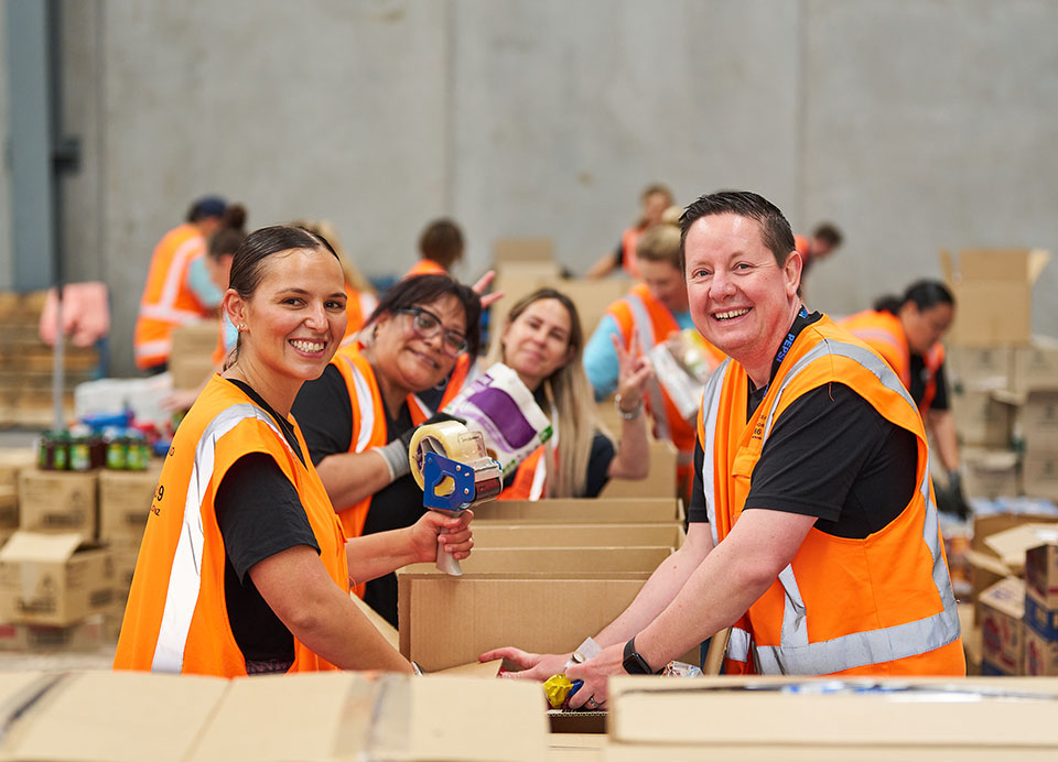 Workers smiling at camera wearing high-vis vests 